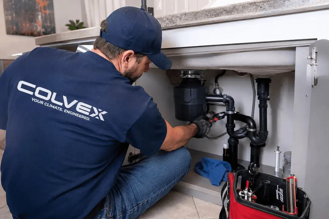 Colvex technician performing plumbing repair at a DFW home